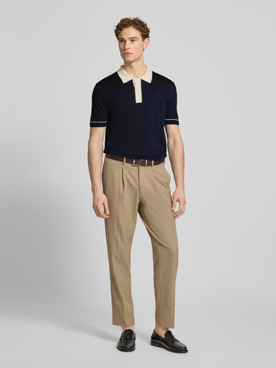 Männermodel trägt Slim Fit Poloshirt mit Logo-Stitching von Gant aus Baumwoll-Modal-Mix, Polokragen, Knopfleiste, Ganzkörperansicht von vorne.