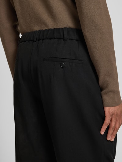 Männermodel trägt Regular Fit Hose mit Leinen-Anteil von Emporio Armani in Schwarz, glatte Textur, Detailaufnahme Rückansicht, Lyocell-Mix.