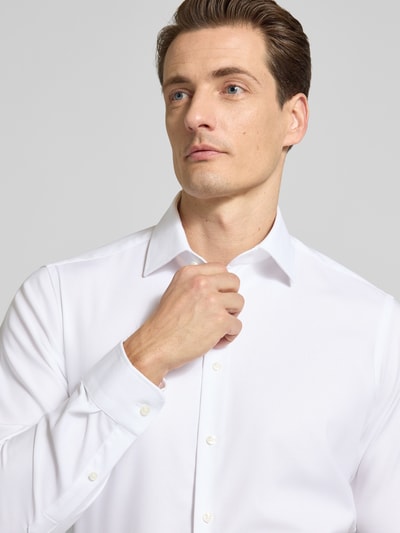 Männermodel trägt Regular Fit Business Hemd mit Kentkragen von Christian Berg Men, weiß, elastischer Baumwoll-Mix, Nahaufnahme Oberkörper.