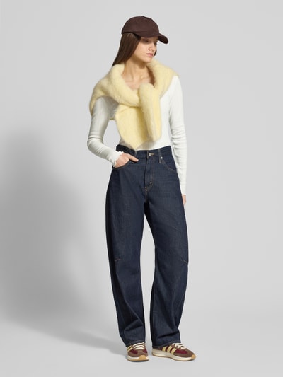 Vrouwenmodel draagt Slim Fit Langarmshirt uit bio-katoenmix model 'TENNA LIFE' van Only, fijn opengewerkt patroon, unikleur, fijngebreid, met frill aan uiteinden, U-boothals, lange mouw, donkergekleurde jeans en lichtgele sjaal, full body vooraanzicht.