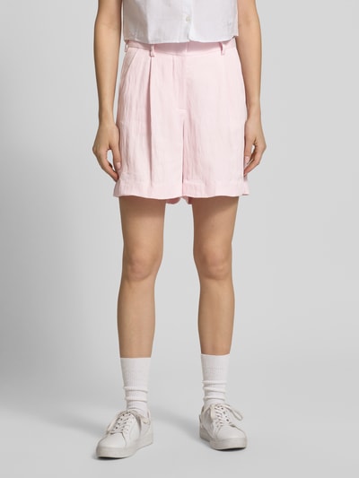 Kobiece model prezentuje szorty z tyłu kieszeń z wypustką model 'EMMA' od JJXX, krój loose fit, zapięcie na haftkę i zamek błyskawiczny, wpuszczane kieszenie, szerokość w rozmiarze S: 37 cm, długość wewnętrzna nogawki w rozmiarze S: 14 cm, jasnoróżowy, gładka tekstura, przód, ujęcie całej sylwetki