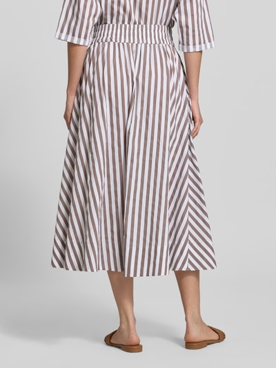 Vrouwenmodel draagt midirok im allover-look met elastische band van Rich & Royal in bruin-witte strepen, puur katoen, A-lijn, totale lengte maat 36: 91 cm, bandwijdte maat 36: 34 cm. Ganzkörperansicht Rückansicht.