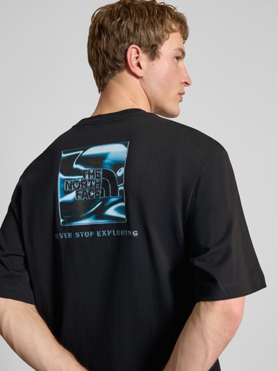Männermodel trägt Oversized T-Shirt mit Logo und Rundhalsausschnitt von The North Face in Schwarz, reine Baumwolle, Rückenlänge 73 cm, Ganzkörperansicht Rückansicht