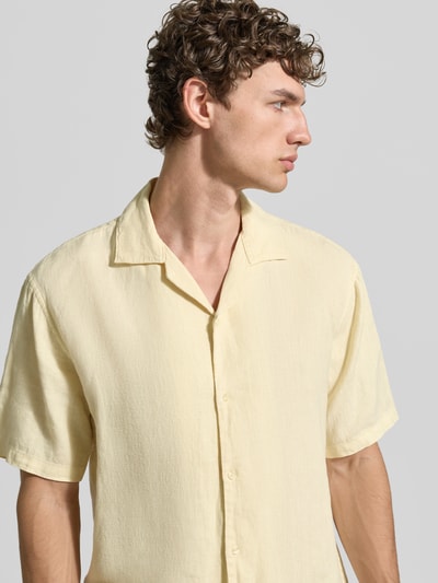 Männermodel trägt Regular Fit Leinenhemd mit Reverskragen van MCNEAL, lichtgeel, puur linnen, korte mouw, knoopsluiting, halflichaams close-up voorkant