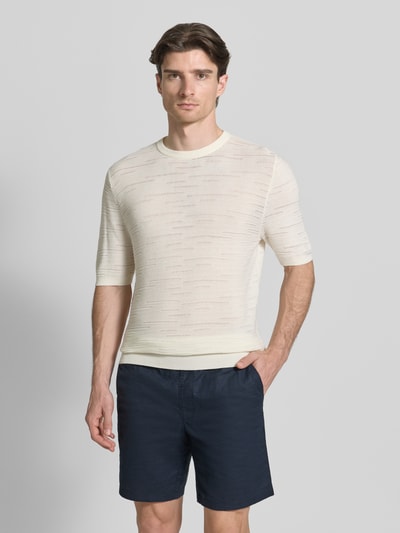 Männermodel trägt Strickshirt aus Baumwolle von Antony Morato in Creme, gerader Schnitt, Halbarm, gerippte Abschlüsse, Ganzkörperansicht von vorne.