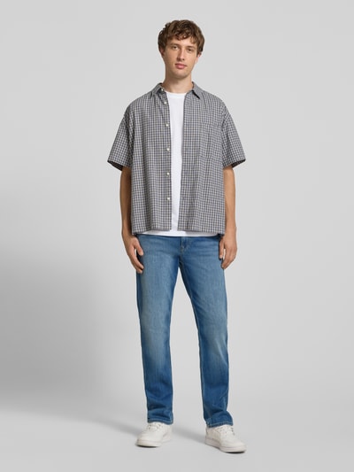 Männermodel trägt Straight Fit Jeans aus Baumwoll-Mix Modell 'Cash' von Pepe Jeans in Hellblau vor grauem Hintergrund, Ganzkörperansicht von vorne. Herren Straight Fit Jeans von Pepe Jeans.