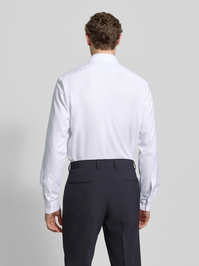 Männermodel trägt weißes Modern Fit Businesshemd mit extra langem Arm von OLYMP aus reiner Baumwolle, Rückenansicht Ganzkörperansicht.