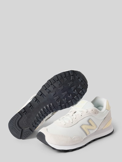 Produktfoto, Sneaker mit Schnürung Modell '515' von New Balance, beige und weiß mit abgerundeter Spitze, Label-Details sichtbar, Damenschuh, texturierte Sohle, Absatzhöhe 3 cm, Schafthöhe 8 cm, Schaftweite 8 cm, schlichter Hintergrund.