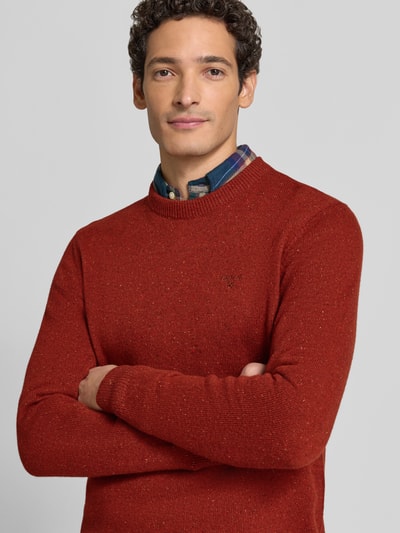 Männermodel trägt Pullover aus Woll-Seide-Mix mit Rundhalsausschnitt Modell 'TISBURY' von BARBOUR in Rostrot, Stricktextur, Nahaufnahme Oberkörper. Unifarbener Herren Strickpullover mit geripptem Rundhals, langen Ärmeln und gerippten Abschlüssen.