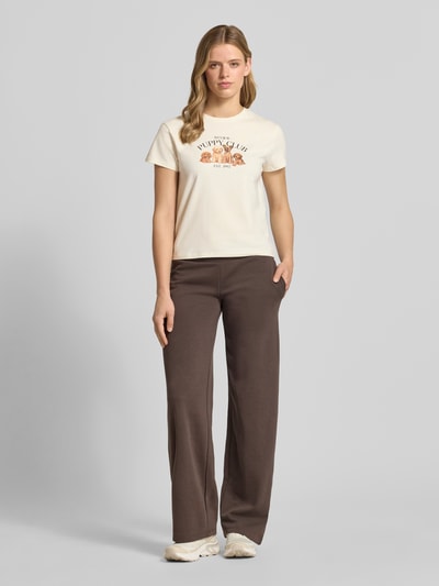 Vrouwenmodel draagt T-shirt met motiefprint en ronde hals van REVIEW, mix van katoen en elastaan, regular fit, ruglengte maat S 51 cm, lichte tinten, gladde textuur, rechte vormen, Ganzkörperansicht von vorne.