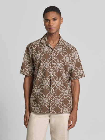 Mannelijk model draagt Regular Fit vrijetijdsoverhemd uit mix van linnen en katoen van MCNEAL, bruin met wit stitchingmotief, reverskraag, 1/2-mouwen, ruglengte maat M 71 cm, schouderbreedte 46 cm, mouwlengte 26 cm, ganzekörperaanzicht van voren.
