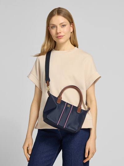 Kobiece modelka nosi Henkeltasche mit gestickten Kontraststreifen od Tommy Hilfiger, efekt: jednolity kolor, zamek błyskawiczny, główna przegroda, przegródka wewnętrzna zapinana na zamek błyskawiczny, aplikacja z logo z metalu, uchwyt, odpinany pasek na ramię, widok całej sylwetki od przodu.