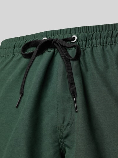 Produktfoto, Regular Fit Badehose mit Logo-Patch Modell 'Everyday' von Quiksilver in Dunkelgrün, Elastikbund mit Tunnelzug, Detailaufnahme.