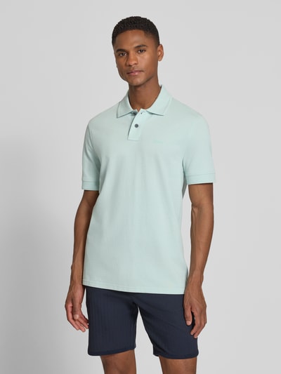 Männermodel trägt Regular Fit Poloshirt aus reiner Baumwolle Modell 'PRIME' von BOSS Orange, Optik: Unifarben, Piqué-Struktur, Label-Applikation, Polokragen, V-Ausschnitt, kurze Knopfleiste, Kurzarm, Ärmelabschluss: Gerippt, Rumpfabschluss: mit Seitenschlitzen, Materialverarbeitung: Piqué, Ganzkörperansicht von vorne.