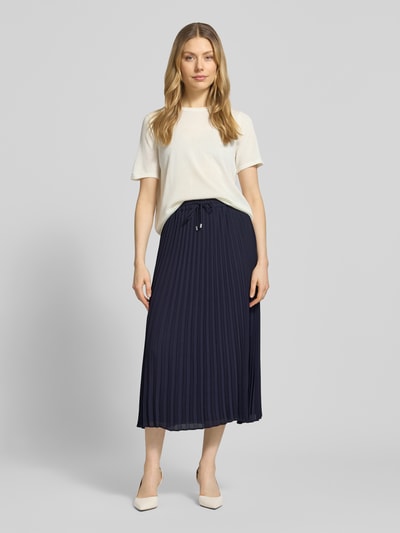 Frauenmodel trägt Midirock mit Plisseefalten von Comma, navy, A-Linie, elastischer Bund mit Tunnelzug, Ganzkörperansicht von vorne.
