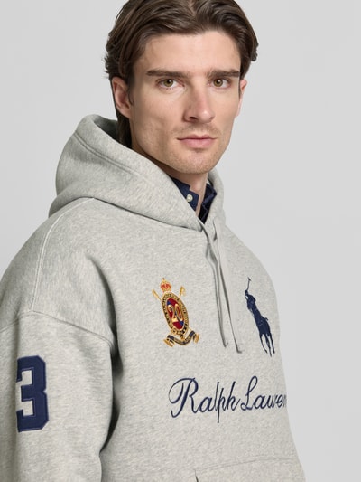Männermodel trägt Hoodie mit Label-Stitchings und Känguru-Tasche von Polo Ralph Lauren, grauer Baumwoll-Mix, Nahaufnahme Oberkörper.