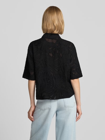 Frauenmodel trägt Regular Fit Bluse aus Viskose-Mix Modell 'Zlowera' von someday, schwarz gemustert, Kombination aus glatter und strukturierter Textur, Ganzkörperansicht Rückansicht.