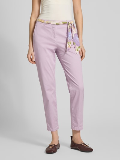 Frauenmodel trägt Slim Fit Chino mit Viskose-Anteil von Christian Berg Woman in Flieder mit abnehmbarem Stoffband, Ganzkörperansicht von vorne.