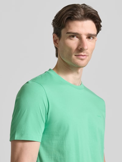 Männermodel trägt Regular Fit T-Shirt aus reiner Baumwolle Modell 'Thompson 01' von BOSS in Unifarben, Nahaufnahme Oberkörper.