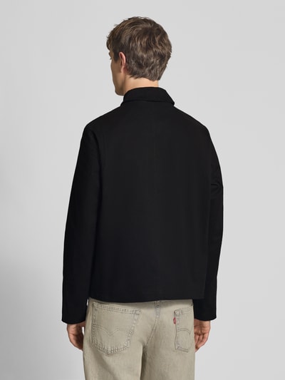 Männermodel trägt schwarze Jacke mit Umlegekragen Modell 'GRAHAM' von Jack & Jones, Regular Fit, Rückansicht, Ganzkörperansicht.
