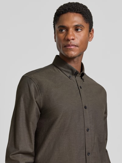 Männermodel trägt Regular Fit Freizeithemd aus Baumwoll-Mix Modell 'Oxford' von Lindbergh in Olivgrün, Nahaufnahme Oberkörper. Baumwoll-Elasthan-Mix, Button-Down-Kragen, 1-Knopf-Manschetten, abgerundeter Saum.