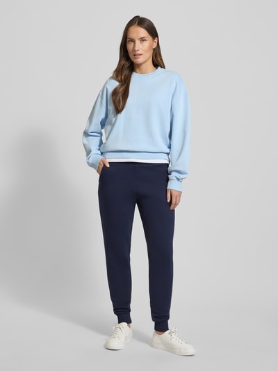 Frauenmodel trägt Sweatpants mit elastischem Bund von Christian Berg Woman aus Baumwoll-Mix, lockerem Schnitt, Tunnelzug, französische Eingrifftaschen, Ganzkörperansicht von vorne.