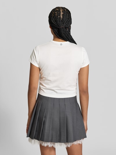 Frauenmodel trägt Regular Fit T-Shirt mit Statement-Print von Rabanne aus reiner Baumwolle, weiß, kombiniert mit grauem, plissiertem Rock, Rundhalsausschnitt, kurzärmelig, Rückenlänge bei Größe S 46 cm, Ganzkörperansicht Rückansicht.