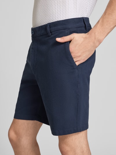 Männermodel trägt Modern Fit Chinoshorts aus Baumwoll-Mix Modell 'KANE1' von BOSS, unifarben, seitliche Taschen, Nahaufnahme Oberschenkel.