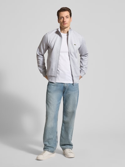 Männermodel trägt Regular Fit Sweatjacke aus Baumwoll-Mix von Lacoste, Optik: Unifarben, Relaxed-Fit, Reißverschluss, Ganzkörperansicht von vorne.