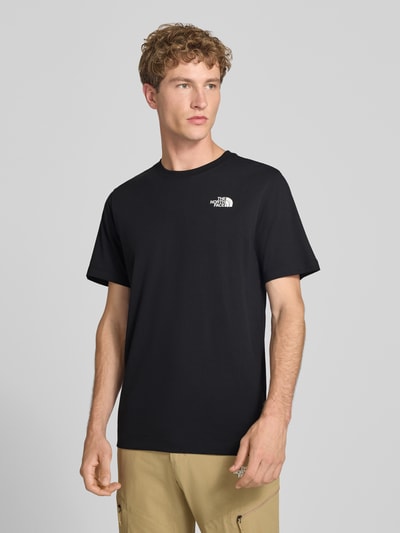 Männermodel trägt zwart t-shirt van katoenmix, regular fit, labelprint, Model 'Evolution' van The North Face, ruglengte maat M 73 cm, Ganzkörperansicht van voren