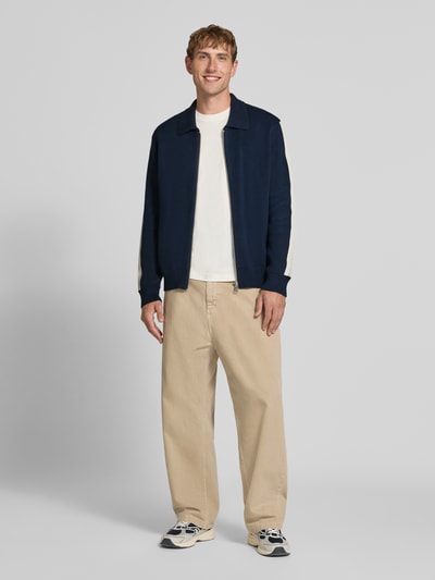 Männermodel trägt Regular Fit gebreid jack uit puur katoen van Marc O'Polo DENIM in marineblauw en beige, ganzkörperansicht von vorne