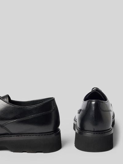 Produktfoto, schwarze Halbschuhe aus echtem Leder Modell 'Derby' von Woolrich mit abgerundeter Passform, Logo-Detail, matter Textur, sichtbarer Absatz von 4 cm, Schafthöhe 7 cm, Schaftweite 10 cm, glatte Oberfläche auf hellem Hintergrund.