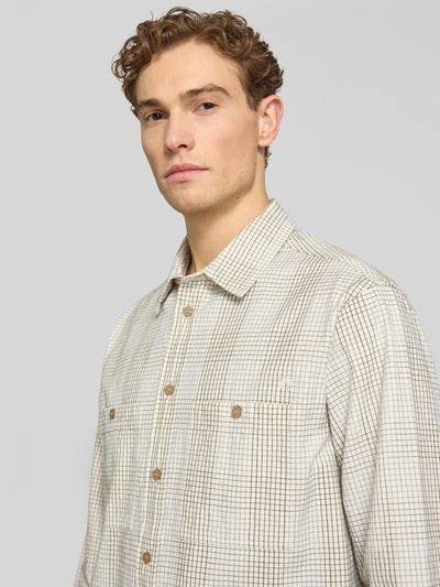 Männermodel trägt Freizeithemd mit Kentkragen Modell 'Cooper' von Wood Wood in Beige mit Karomuster, reine Baumwolle, Nahaufnahme Oberkörper.