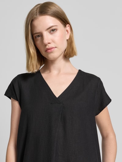 Frauenmodel trägt Knielanges Leinenkleid mit V-Ausschnitt Modell 'Ina' von Soyaconcept im schwarzen Leinen-Mix mit Viskose-Anteil, Loose-Fit, Nahaufnahme Oberkörper.
