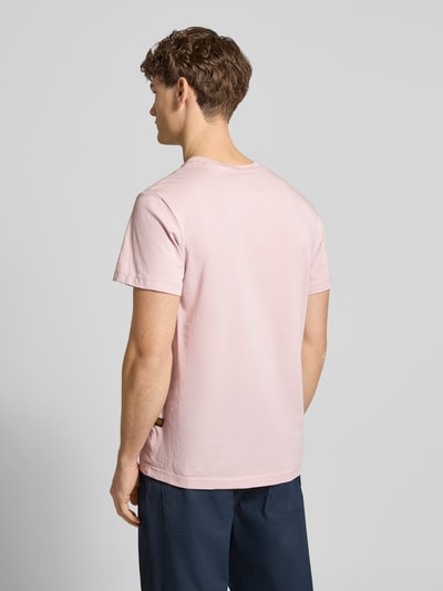 Męski model nosi T-Shirt aus Baumwolle od G-Star Raw w kolorze jasnoróżowym, prosty krój, bawełna, wyhaftowane logo, długość tyłu 71 cm, widok całej sylwetki z tyłu