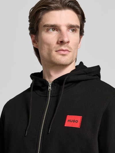 Männermodel trägt Sweatjacke aus Baumwolle Modell 'Daple212' von HUGO, puur katoen, los model, labelpatch, ritssluiting, Nahaufnahme Oberkörper.