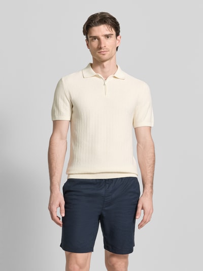 Männermodel trägt Poloshirt mit kurzem Reißverschluss und Polokragen von MCNEAL aus Bio-Baumwolle, Body Fit, Cremefarbe, Ganzkörperansicht von vorne.