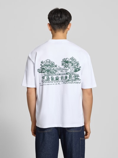 Männermodel trägt Oversized Herren T-Shirt Modell 'Rochefort' von Pegador aus Reine Baumwolle, Motiv-Print Rückseite, Label-Detail, Ganzkörperansicht Rückansicht.