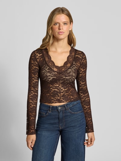 Vrouwenmodel draagt Slim Fit Langarmshirt in Spitzen-Mesh-Optik Modell 'NIKKA' van ONLY in bruin met bloemenpatroon, dames langarmshirt, geheelopname voorkant.