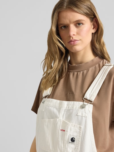 Frauenmodel trägt Overall mit Brusttasche Modell 'BIB' von Carhartt Work In Progress aus Reine Baumwolle, Label-Patch, Eingrifftaschen, Nahaufnahme Oberkörper.