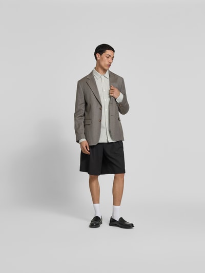 Männermodel trägt Relaxed Fit Freizeithemd mit Brusttasche von Forét, reine Baumwolle, Kentkragen, Langarm, Ganzkörperansicht von vorne.