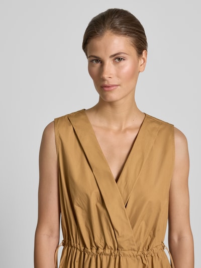 Frauenmodel trägt knielanges Cocktailkleid mit Kordelzug und Kordelstoppern von Rinascimento, baumwollfarben, tailliert, V-Ausschnitt, Nahaufnahme Oberkörper.