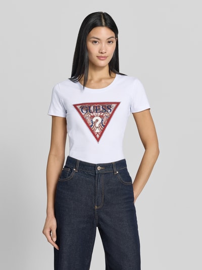 Frauenmodel trägt T-Shirt mit Logo und Rundhalsausschnitt von Guess, weiß, Slim Fit, Baumwoll-Elasthan-Mix, Oberkörperansicht von vorne