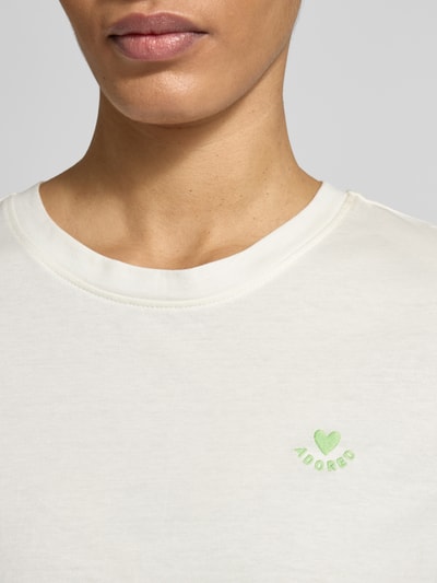 Frauenmodel trägt Regular Fit T-Shirt aus reiner Baumwolle von s.Oliver RED LABEL in Unifarbe mit grüner Stickerei, Nahaufnahme Oberkörper.