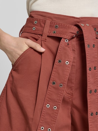 Frauenmodel trägt Regular Fit Shorts aus Baumwoll-Mix Modell 'C_TULINA' von BOSS Orange in Optik: Unifarben mit seitlichen Eingrifftaschen, Bundfalten, Nietengürtel und Paspeltaschen, Material Baumwoll-Mix, Nahaufnahme Oberkörper.