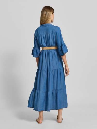 Frauenmodel trägt Jeanskleid mit Gürtel und Rüschenärmel Modell 'Li44yanaa' von ZABAIONE im mittellangen, blauen Volant-Design aus Lyocell mit Serafino-Kragen, kurzer Knopfleiste und Herzschnalle; tailliert, Rückansicht Ganzkörperansicht.