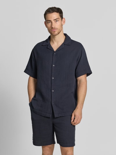 Männermodel trägt Relaxed Fit Freizeithemd mit Strukturmuster von Lindbergh in Dunkelblau, Reine Baumwolle, Reverskragen, Kurzärmelig, durchgehende Knopfleiste, Rückenlänge 80 cm, Schulterbreite 47 cm, Ärmellänge 29 cm, Ganzkörperansicht von vorne.