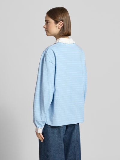 Frauenmodel trägt Relaxed Fit Poloshirt mit Label-Stitching Modell 'Jolina' von OH APRIL, Reine Baumwolle, Spitzenbesatz, hellblau, Ganzkörperansicht Rückansicht.