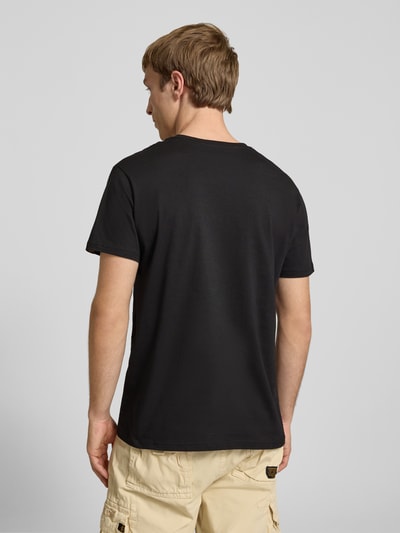 Männermodel trägt T-Shirt mit Logo und Rundhalsausschnitt von Alpha Industries in Schwarz, Reine Baumwolle, Regular-Fit, Rückenlänge 67 cm, Ganzkörperansicht Rückansicht.