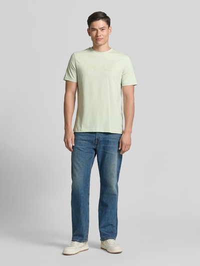 Mannenmodel draagt Regular Fit T-shirt uit puur katoen model 'TE_LOGO' van BOSS in look: effen met logoprint, ronde hals, korte mouw, materiaal: puur katoen, Ganzkörperansicht von vorne.